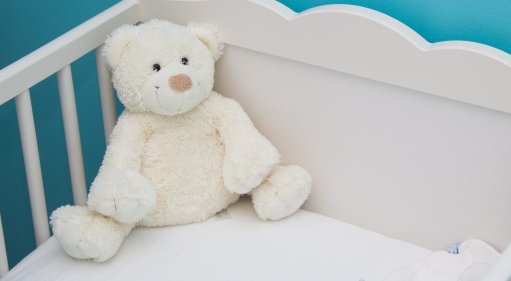 baby crib with white teddy bear